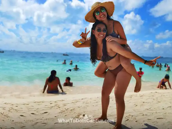 young girls having fun enjoying beach club in isla mujeres catamaran wha to do in cancun